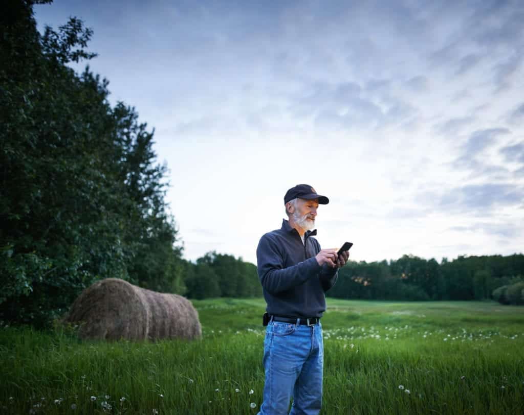 man standing in field contacting mcsnet remotely